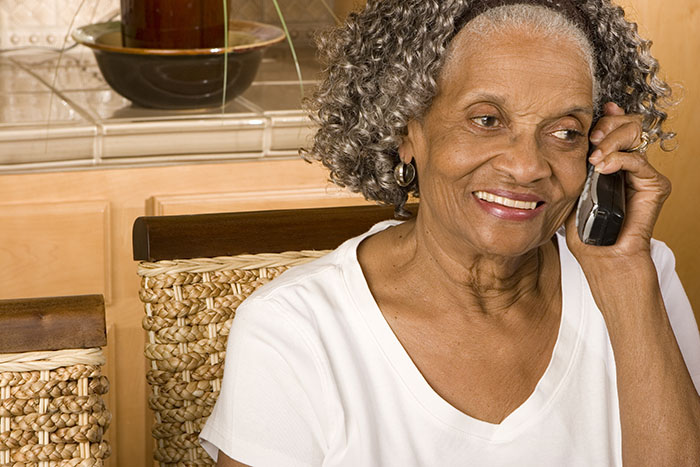 Elderly woman indoors using the phone