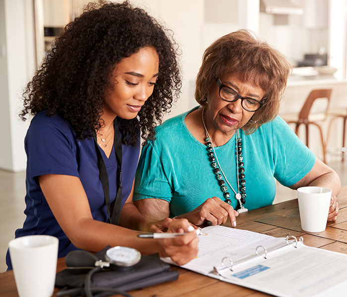 Female healthcare worker with a senior woman during a home care health check-in