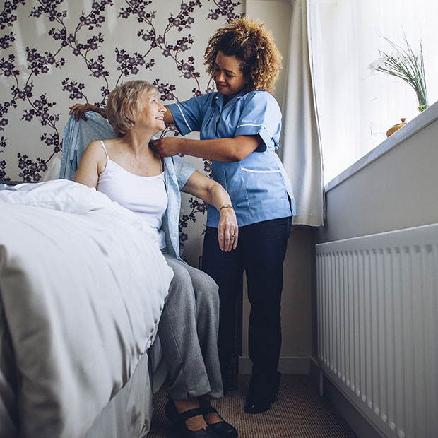 Nurse helping woman out of bed