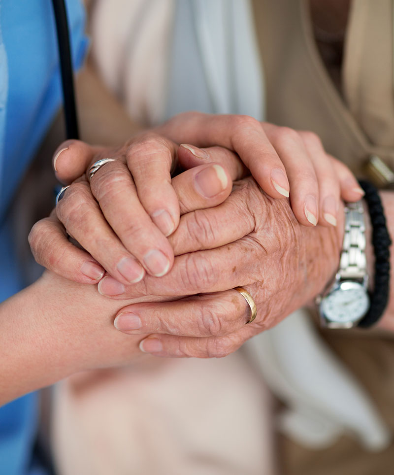 Caregiver holding Elderly mans hand